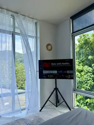 a bedroom with a television and a large window at Jungle House Phuket - Seaview Retreat in Patong Beach