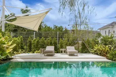 a swimming pool with two chairs and a table next to a house at Akal pool villa 3BR near Laguna, Bangtao & Beach in Bang Tao Beach