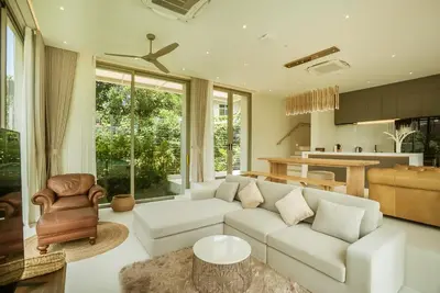 a living room with a white couch and a chair at Akal pool villa 3BR near Laguna, Bangtao & Beach in Bang Tao Beach