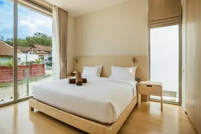 a bedroom with a large bed with a teddy bear on it at Akal pool villa 3BR near Laguna, Bangtao & Beach in Bang Tao Beach