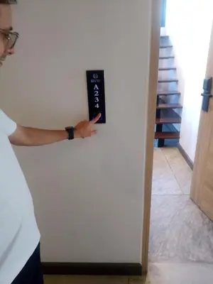 a man is pointing at a sign on a wall at Utopia Naiharn Loft Condo in Rawai Beach