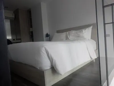 a white bed with white sheets and pillows at Utopia Naiharn Loft Condo in Rawai Beach