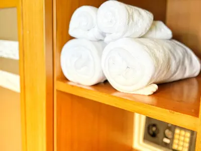 a pile of white towels on a shelf at Patong Leisure Hotel in Patong Beach