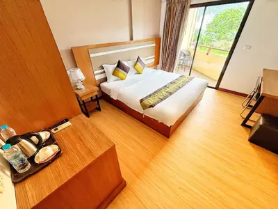 a hotel room with a bed and a table at Patong Leisure Hotel in Patong Beach
