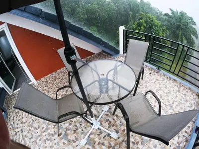 a glass table and two chairs on a balcony at Krabi Top Sea Hill Villa in Klong Muang Beach