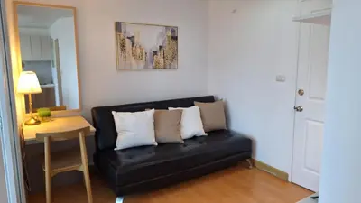 a black couch in a room with a table and a mirror at Plus 2 condo by Tida 111 in Kathu