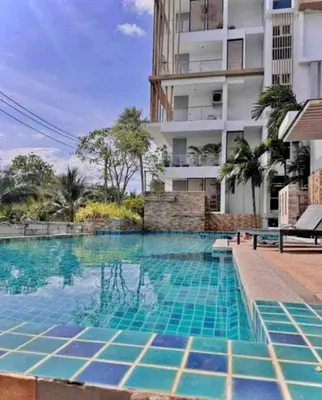 a swimming pool in front of a building at Plus 2 condo by Tida 111 in Kathu