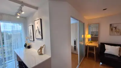 a white room with a table and a couch and a window at Plus 2 condo by Tida 111 in Kathu