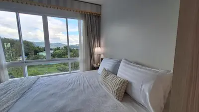 a bedroom with a bed and a large window at Plus 2 condo by Tida 111 in Kathu