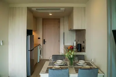 a kitchen with a table with chairs and a dining room at Luxury Ozone Bang Tao 1 Bdr in Laguna Phuket