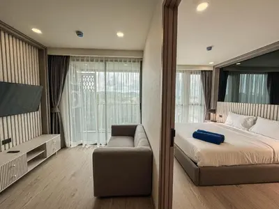 a bedroom with a bed and a couch and a tv at Luxury Ozone Bang Tao 1 Bdr in Laguna Phuket