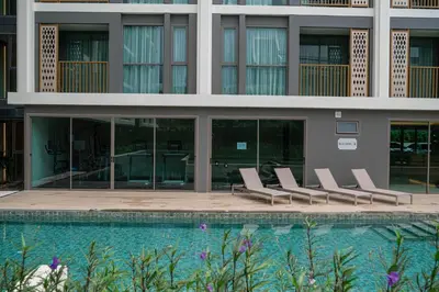 a row of lounge chairs next to a swimming pool at Luxury Ozone Bang Tao 1 Bdr in Laguna Phuket
