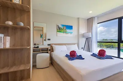 a bedroom with a bed with red hats on it at Space 404 - 1BDR with Coworking, Pool & Gym Access in Bang Tao Beach