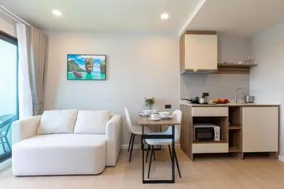 a living room with a white couch and a table at Space 404 - 1BDR with Coworking, Pool & Gym Access in Bang Tao Beach