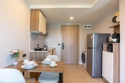 a small kitchen with a table and a refrigerator at Space 404 - 1BDR with Coworking, Pool & Gym Access in Bang Tao Beach