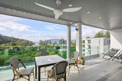 a patio with a table and chairs and a ceiling fan at Spectacular two bed penthouse amazing sea views in Patong Beach