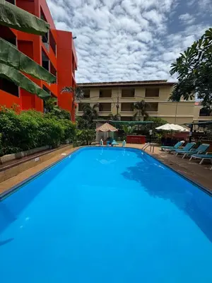 a large blue swimming pool in front of a building at THE PORTERHOUSE Boutique Hotel in Patong Beach