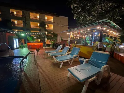 a row of blue chairs next to a swimming pool at night at THE PORTERHOUSE Boutique Hotel in Patong Beach