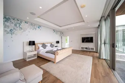 a bedroom with a bed and a tv and a couch at Seascape 6BR Prestige Villa Skyline Pool in Kamala Beach