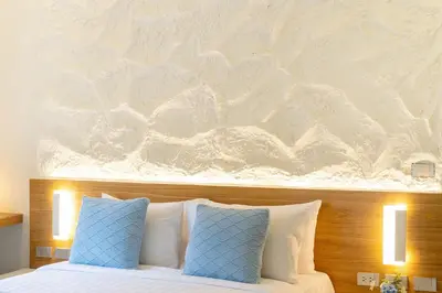 a bed with two pillows and a painting above it at Stylish Studio with Pool - 8' walk to Rawai Beach - 