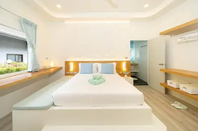 a bedroom with a white bed and a window at Stylish Studio with Pool - 8' walk to Rawai Beach - 