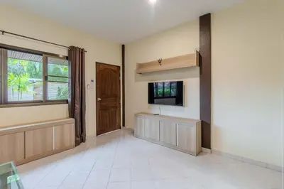 a living room with a tv and a window at V247 Poolside 1BR Near Naiharn Beach & Gym in Rawai Beach