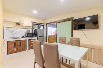 a kitchen and dining room with a white table and chairs at V247 Poolside 1BR Near Naiharn Beach & Gym in Rawai Beach