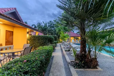 a resort with a palm tree next to a pool at V247 Poolside 1BR Near Naiharn Beach & Gym in Rawai Beach