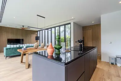 a kitchen and living room with a table and a couch at V253 Brand New 2BR with Pool and Full Kitchen in Thalang