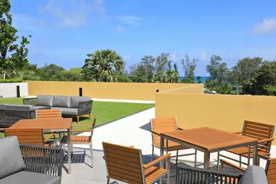 a patio with tables and chairs and a fence at 3bdr new apartmet in Laguna 50m form beasch LBS-3504 in Bang Tao Beach