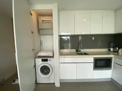a kitchen with white cabinets and a washing machine at 2bdr Apartment in Laguna Bangtao OCS-306 in Bang Tao Beach