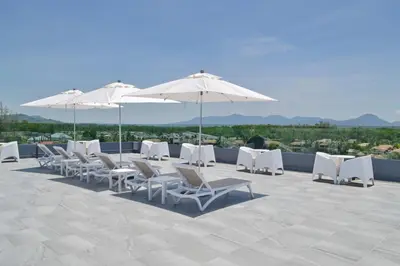 a group of white chairs and umbrellas on a patio at 2bdr Apartment in Laguna Bangtao OCS-306 in Bang Tao Beach