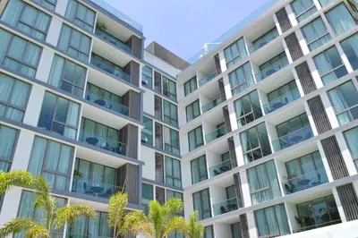 an apartment building with palm trees in the foreground at 2bdr Apartment in Laguna Bangtao OCS-306 in Bang Tao Beach