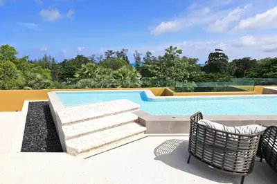 a swimming pool with two chairs and a table and a swimming pool at 2bdr New Apartment in Laguna near Bangtao Beach LBS-4203 in Bang Tao Beach