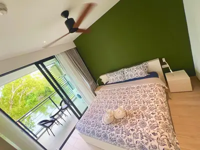 a bedroom with a bed and a green wall at 1-bedroom apartment, Cassia Phuket in Laguna Phuket