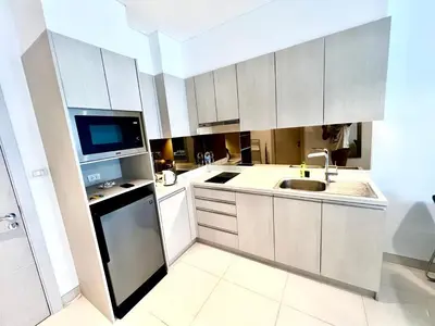 a white kitchen with a sink and a microwave at 1-bedroom apartment, Cassia Phuket in Laguna Phuket