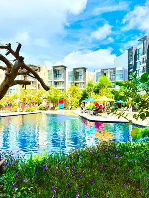 a large swimming pool in a city with buildings at 1-bedroom apartment, Cassia Phuket in Laguna Phuket