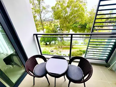 a balcony with two chairs and a table and a window at 1-bedroom apartment, Cassia Phuket in Laguna Phuket