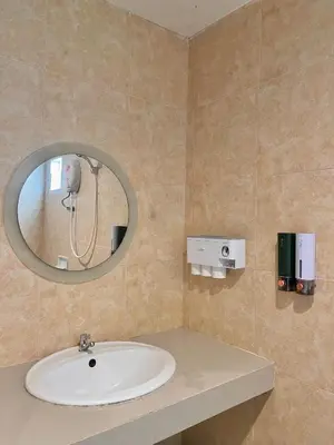 a bathroom with a sink and a mirror at Pluemjai mansion in Kathu