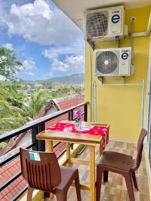 a balcony with a table and chairs and a fan at Pluemjai mansion in Kathu