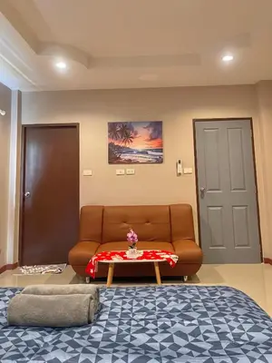 a living room with a couch and a table at Pluemjai mansion in Kathu