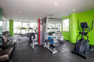 a gym with green walls and tread machines at Квартира в центре Бангтао в комплексе The Regent Bangtao in Bang Tao Beach
