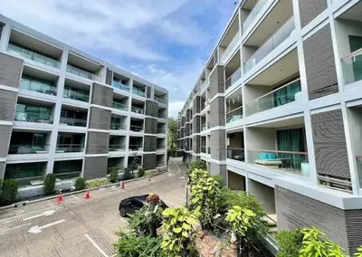 an apartment building with a car parked in a parking lot at Квартира в центре Бангтао в комплексе The Regent Bangtao in Bang Tao Beach