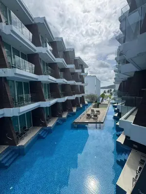 a swimming pool in front of a building at Beachside Bliss in Ban Saiyuan (1)