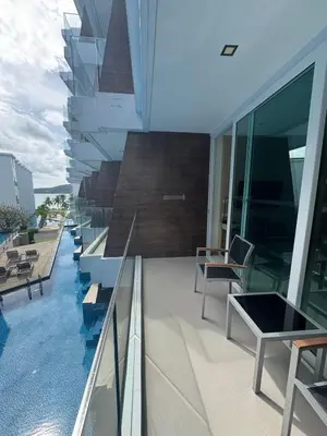 a balcony of a building with a swimming pool at Beachside Bliss in Ban Saiyuan (1)