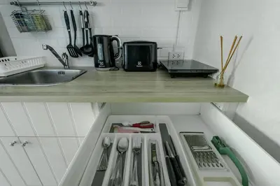 a kitchen drawer with utensils on a counter next to a sink at Cozy apartment by the sea F410 in Nai Yang Beach