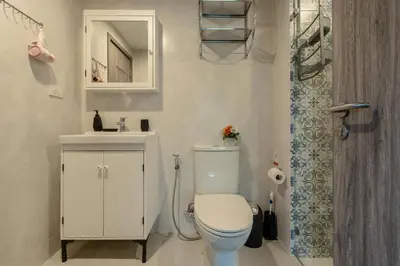 a bathroom with a toilet and a sink and a shower at Cozy apartment by the sea F410 in Nai Yang Beach