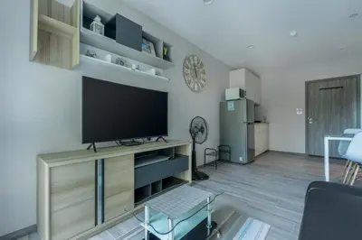a living room with a flat screen tv on a entertainment center at Cozy apartment by the sea F410 in Nai Yang Beach