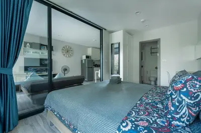 a bedroom with a bed and a large glass window at Cozy apartment by the sea F410 in Nai Yang Beach