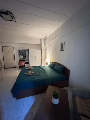a bedroom with a large bed and a table at Hana apartment in Patong Beach